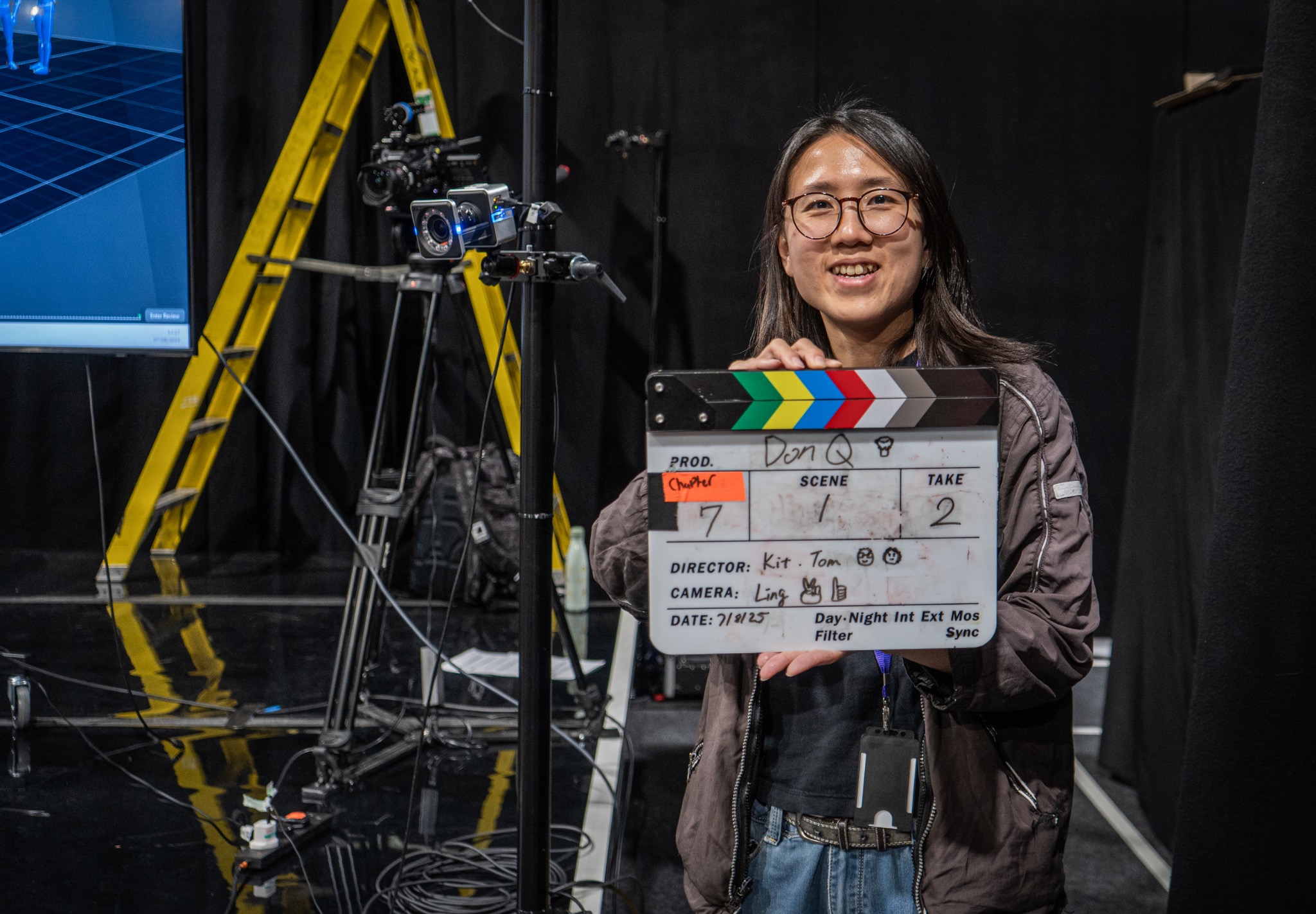 Crew member holding a clapperboard on a motion capture stage